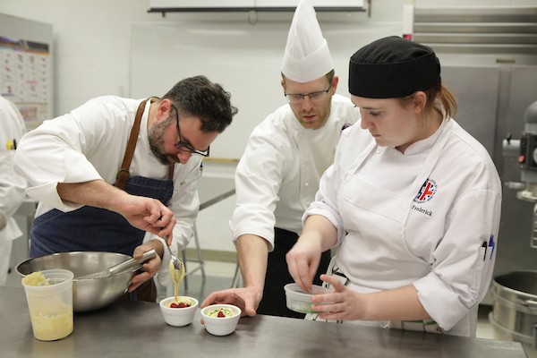 Chef Albert Ponzo and Chef Scott Royce work with a first year student to prepare desserts.